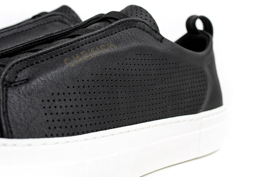 Black ZEN sneakers by Shopify, showcasing sleek design and comfortable fit in a close-up image.