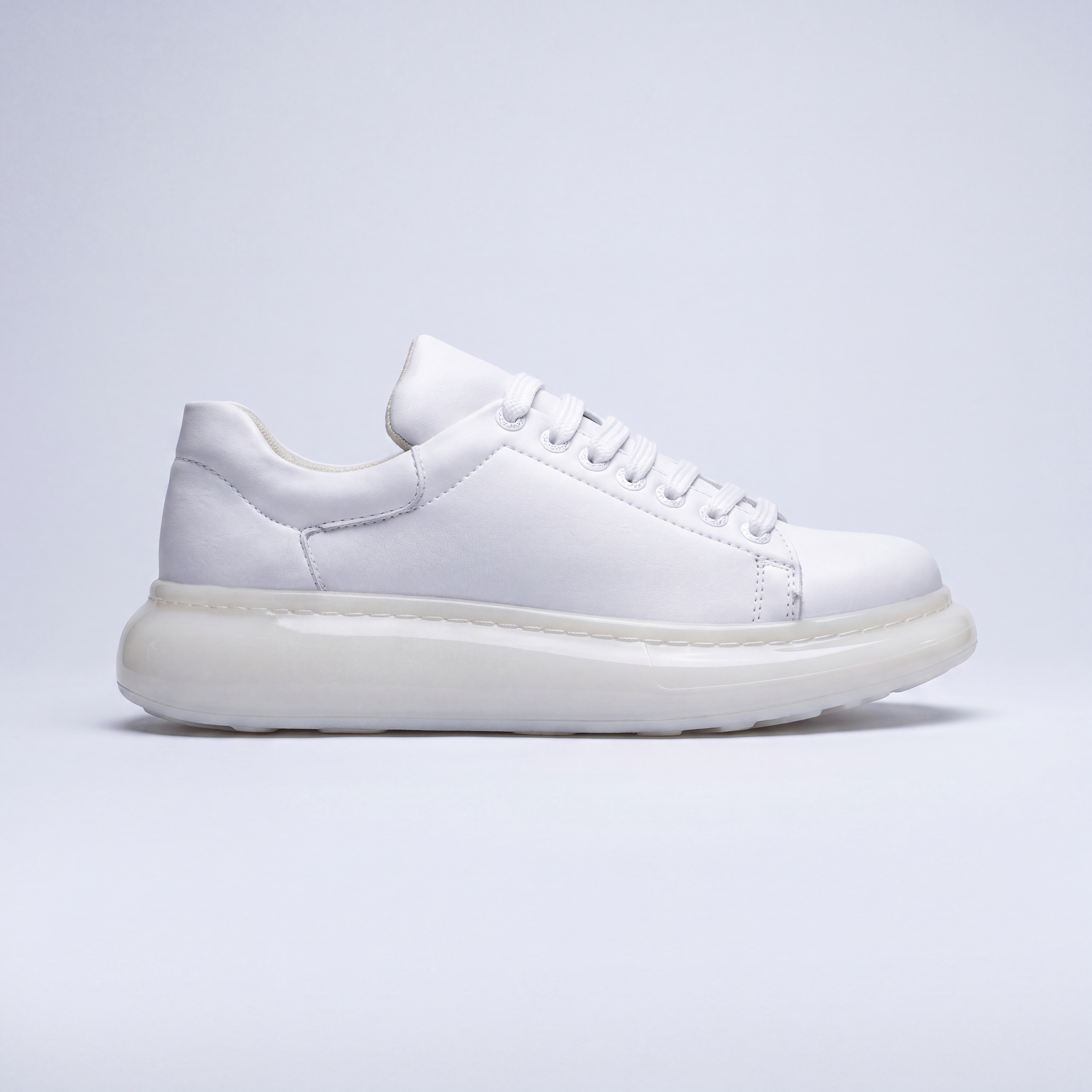 White FANTASIA X sneakers by Shopify with sleek design, white laces, and stylish silhouette on a plain background.