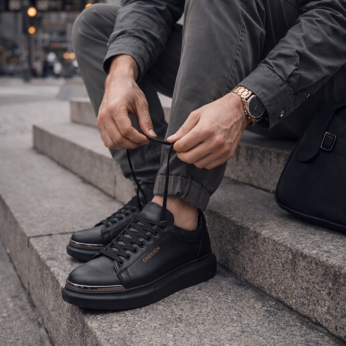 Chekich FANTASIA ST sneakers worn on stone steps, lacing up with grey trousers