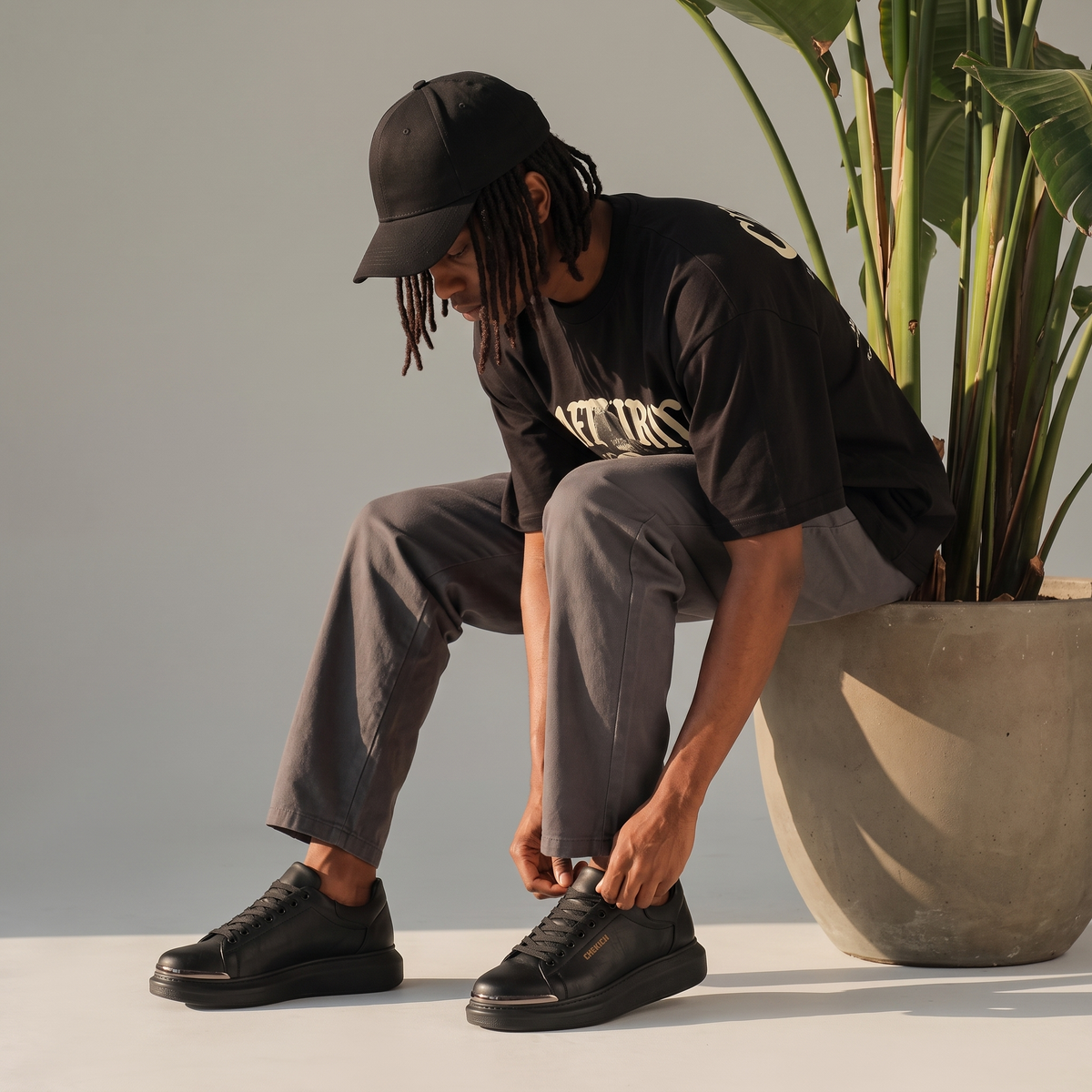 Chekich FANTASIA ST sneakers worn by a seated man in a black cap lacing up