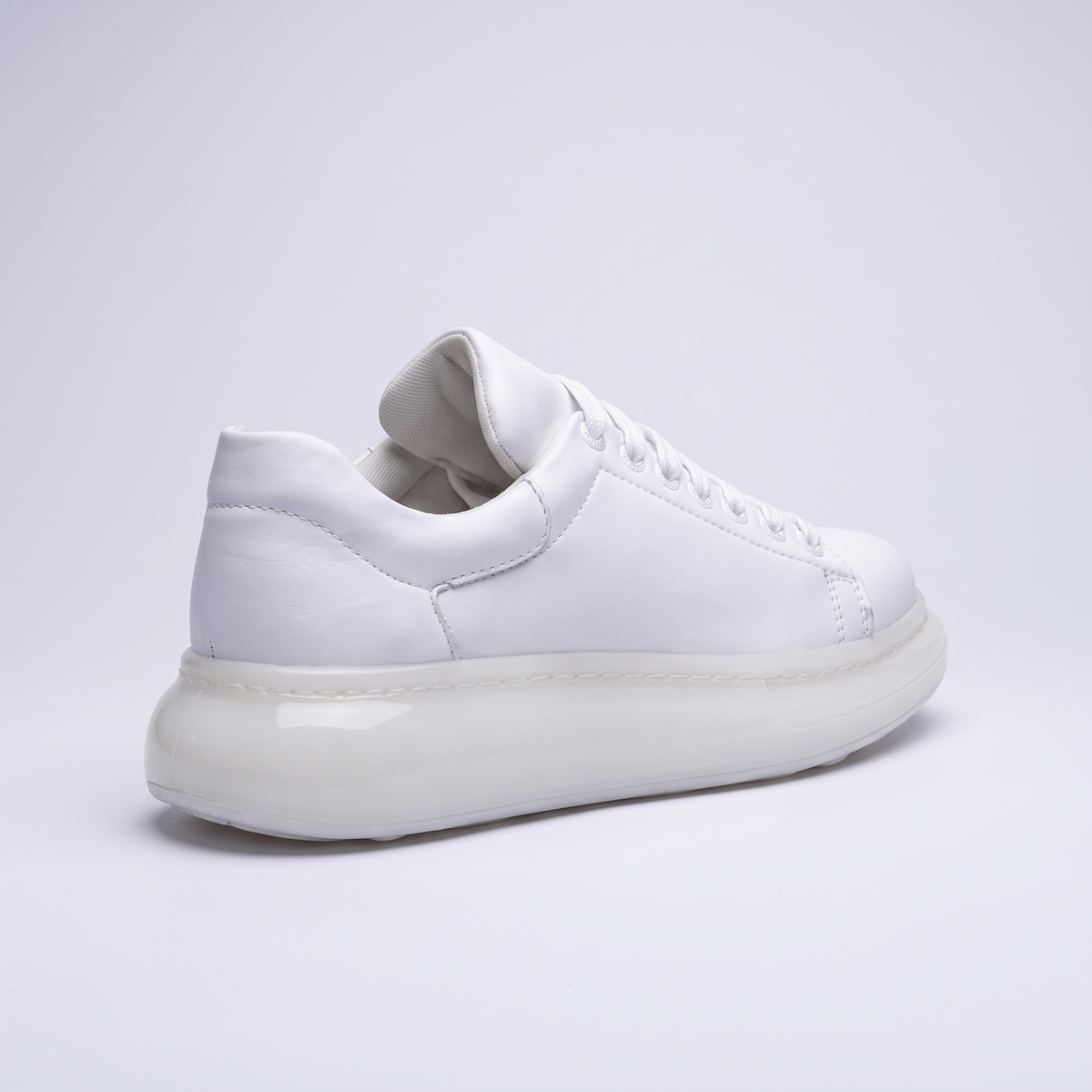 White FANTASIA X sneakers by Shopify, featuring sleek design and modern style, shown from a side view.