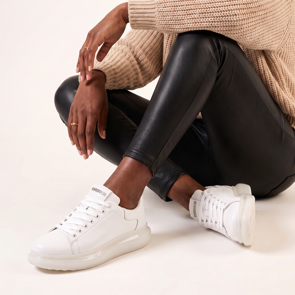 White Shopify Fantasia X sneakers with sleek design and white laces, displayed on a neutral background.