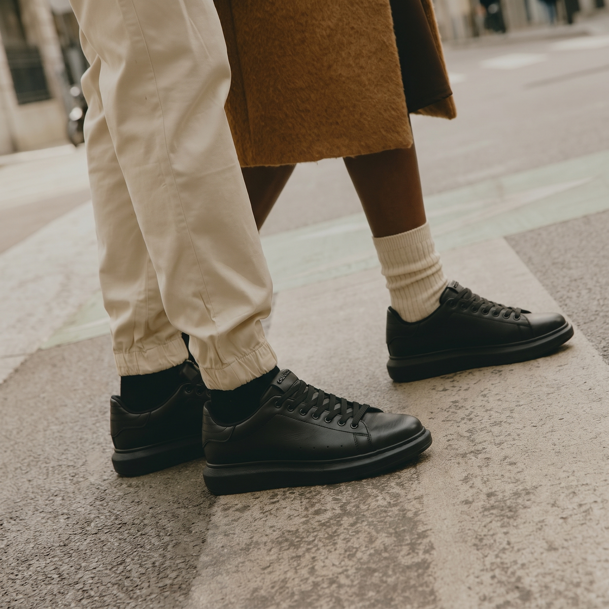 Black ORIGIN Sneakers by Shopify featuring sleek design and comfortable fit, shown from a side view.