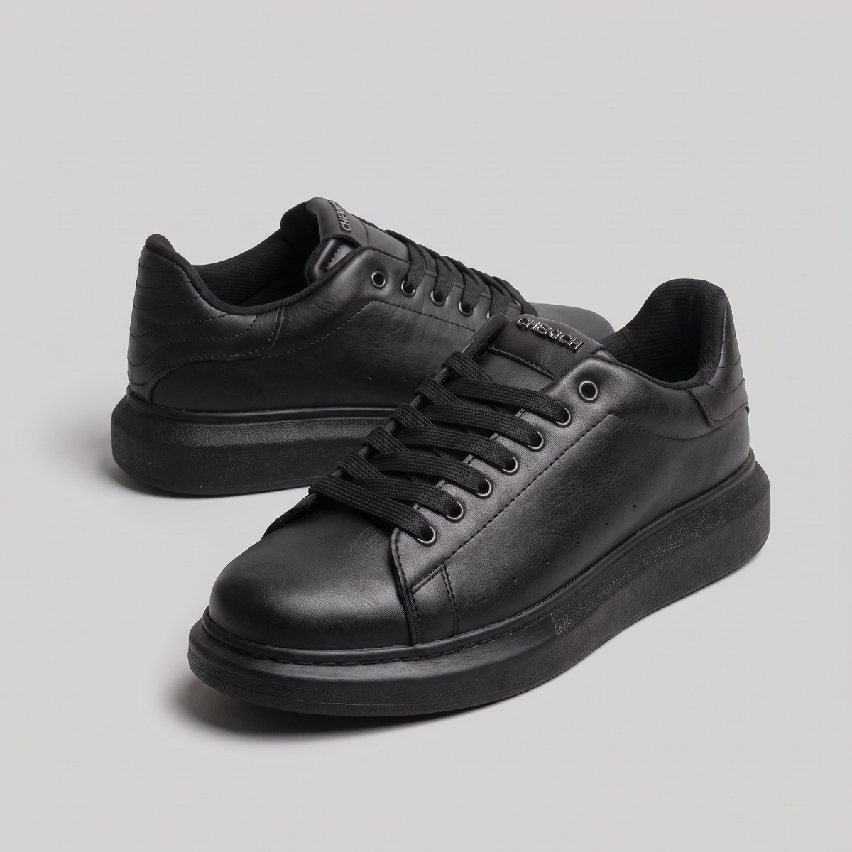 Black ORIGIN Sneakers by Shopify featuring sleek design and smooth black material with subtle branding details.