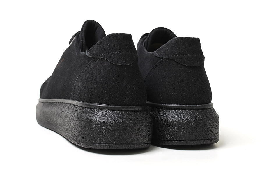 Black suede sneakers from Shopify with sleek design and mirror finish, featuring a modern silhouette and textured sole.