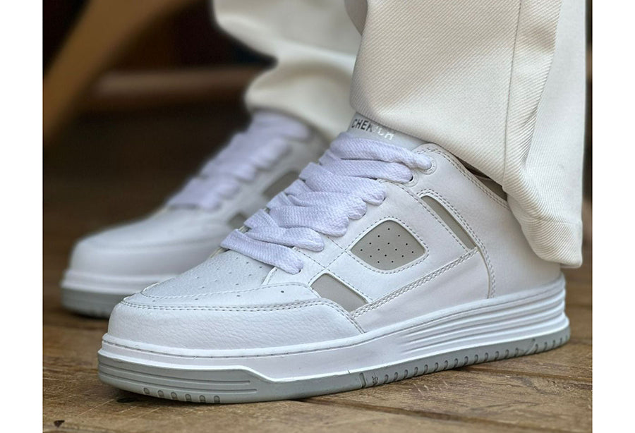 White Blur sneakers by Shopify, showing the stylish cream-colored athletic shoes with a modern design and clean laces.