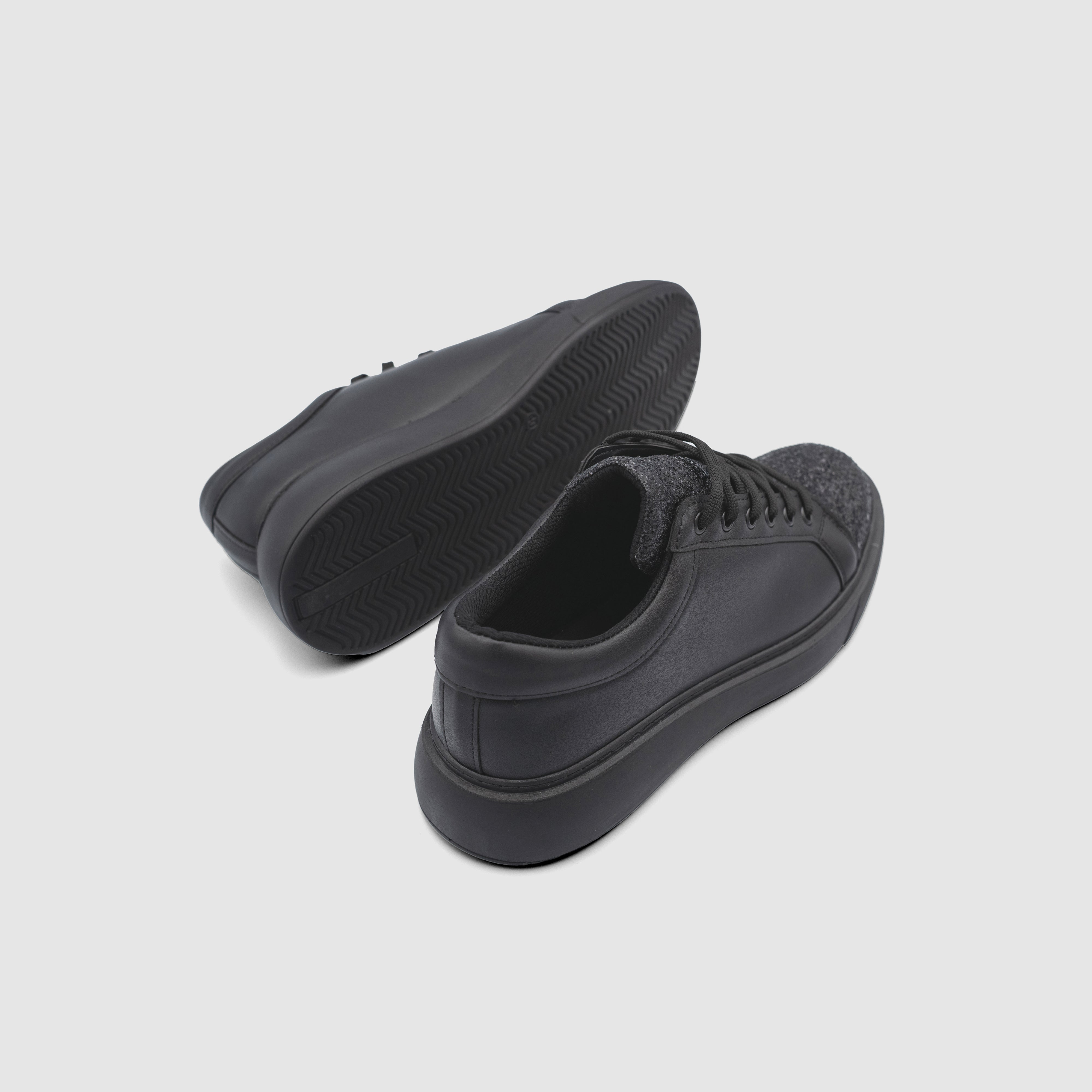 Black Shopify Nova sneakers with sleek design and white soles, showcasing stylish and comfortable footwear.
