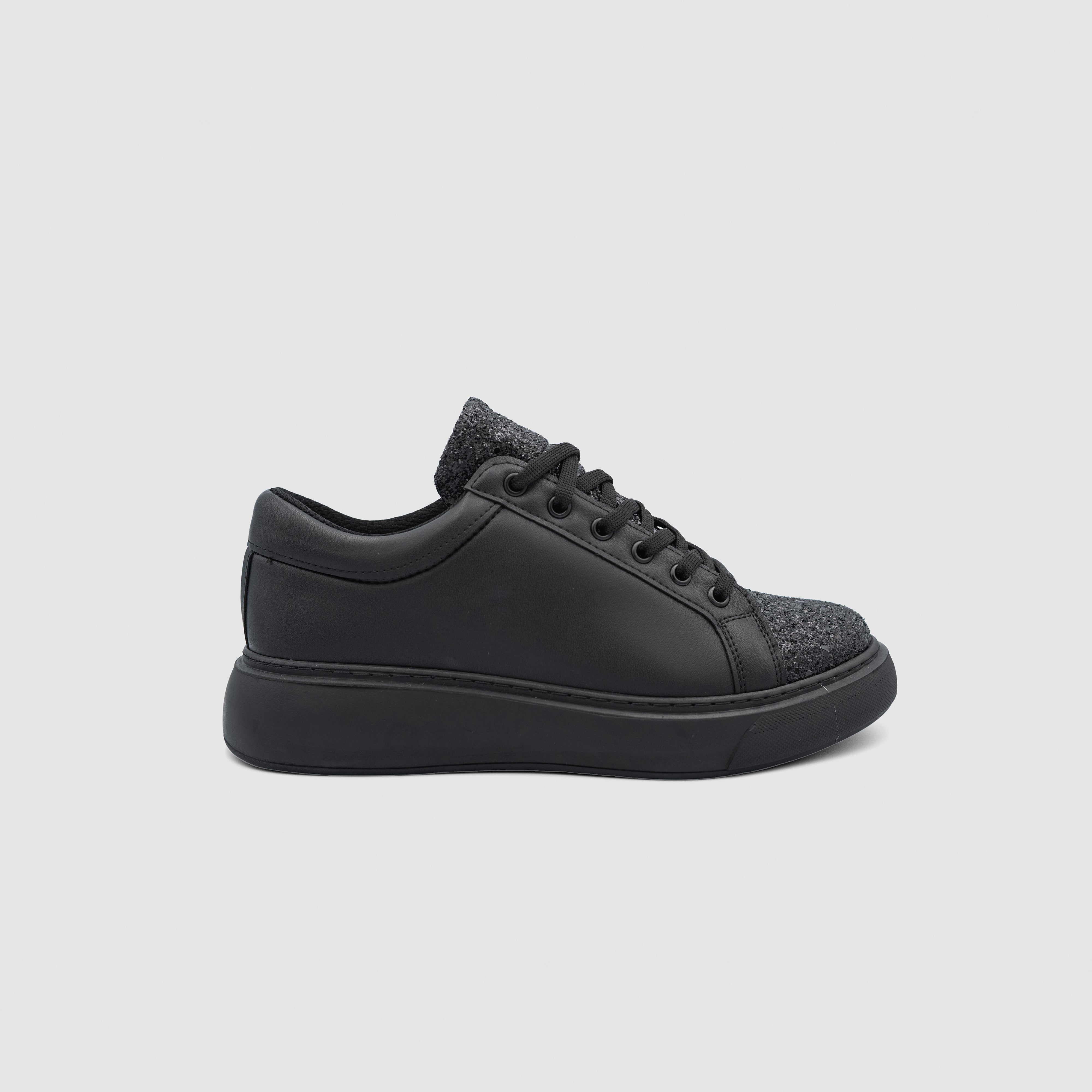 Black Shopify Nova sneakers with sleek design and white sole, displayed on a plain background.
