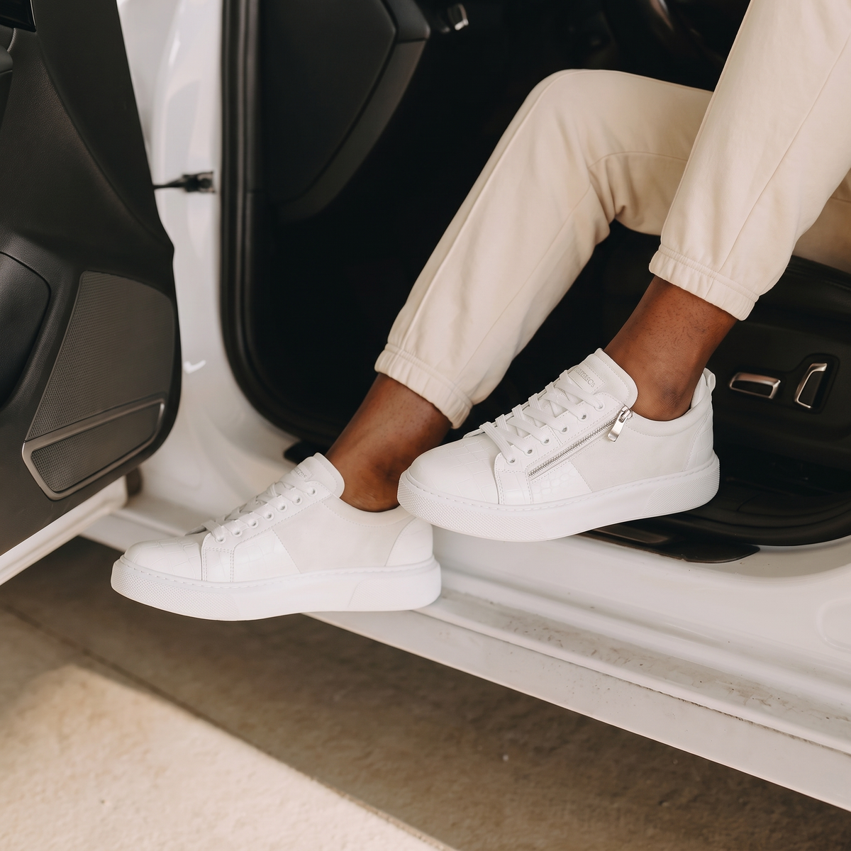 Chekich PHANTOM White sneakers worn with beige trousers stepping out of a car