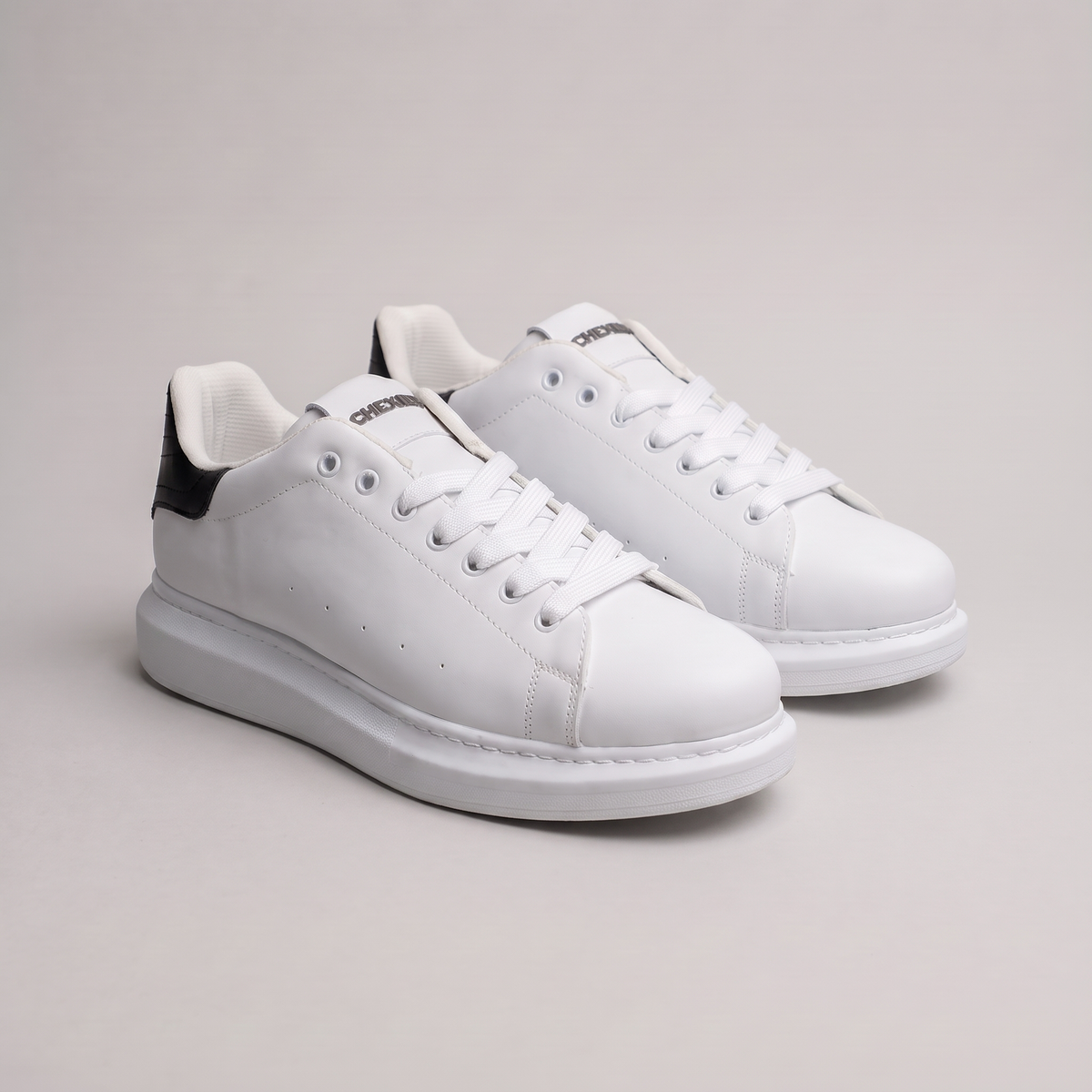 Black Shopify ORIGIN Sneakers with sleek design and white sole, shown from side view on a white background.