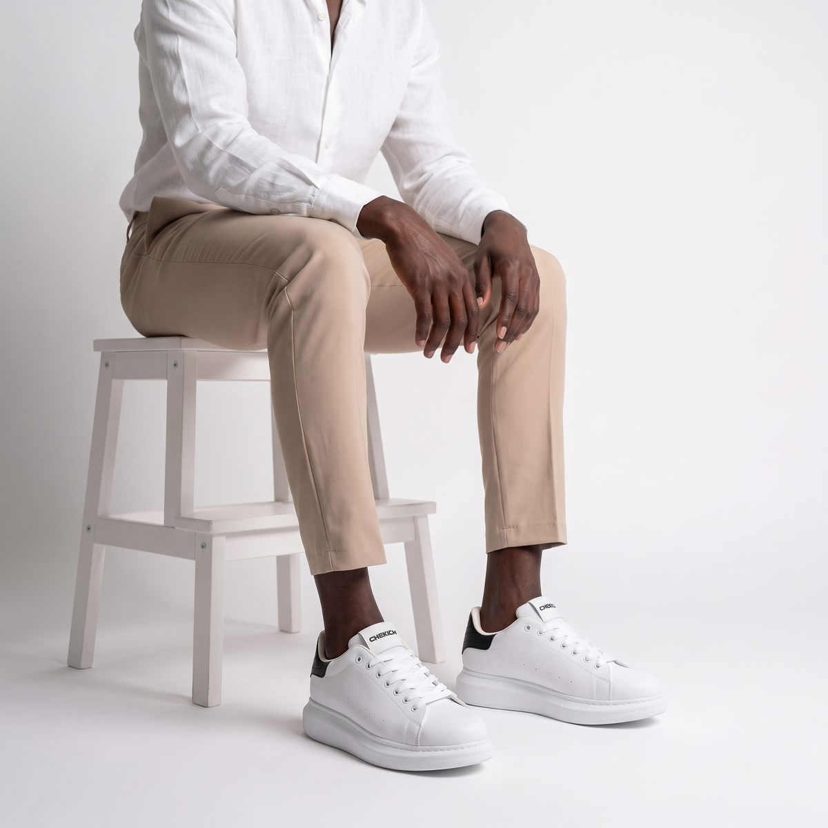 Black Shopify ORIGIN sneakers with sleek design and white sole, shown from a side view on a white background.