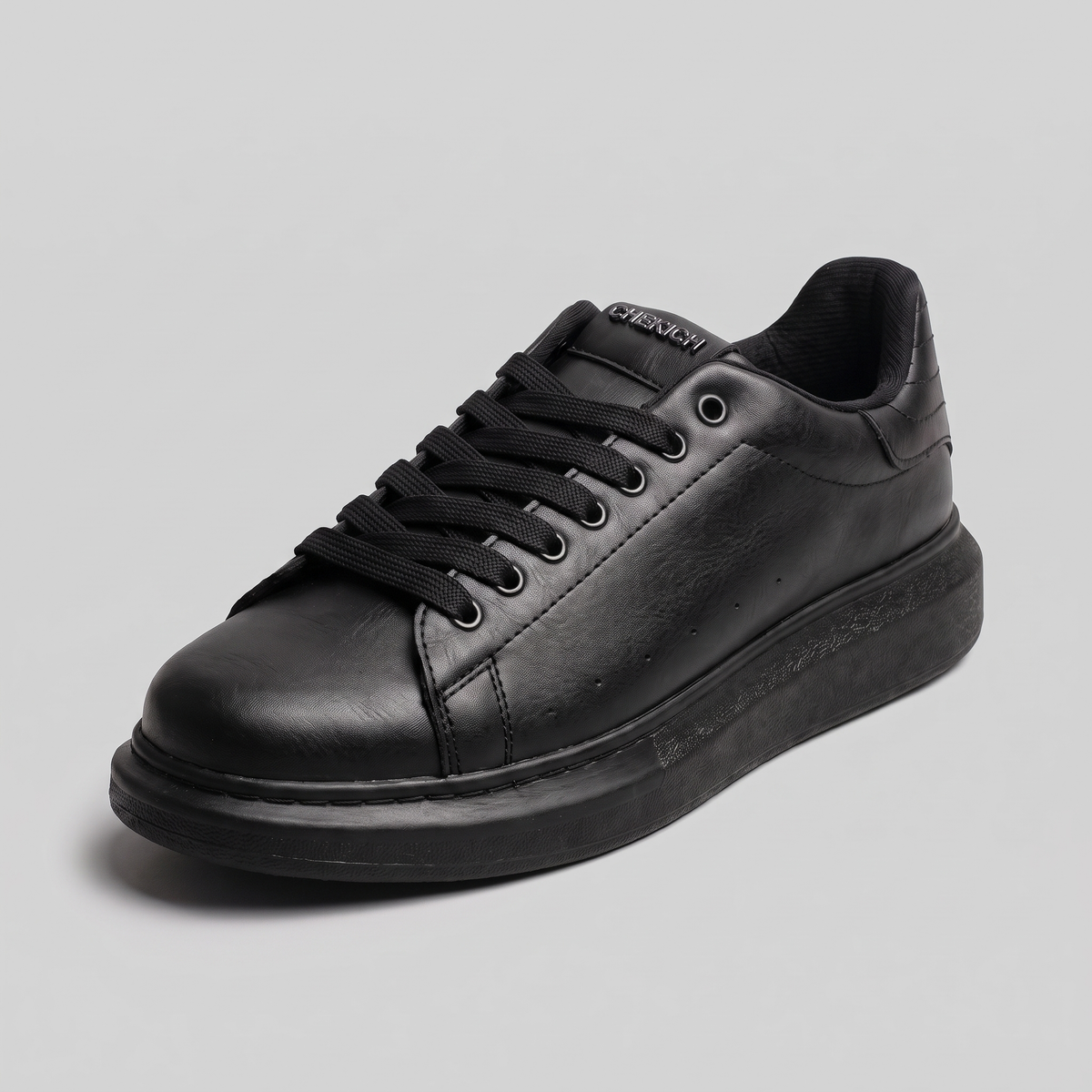 Chekich ORIGIN All Black sneaker, side angle showing the suede heel accent