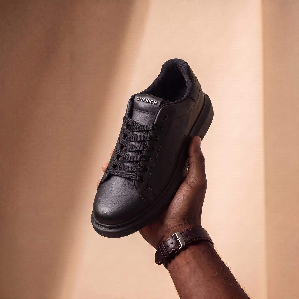 Black ORIGIN sneakers by Shopify featuring sleek design, laced closure, and minimalist style for casual wear.