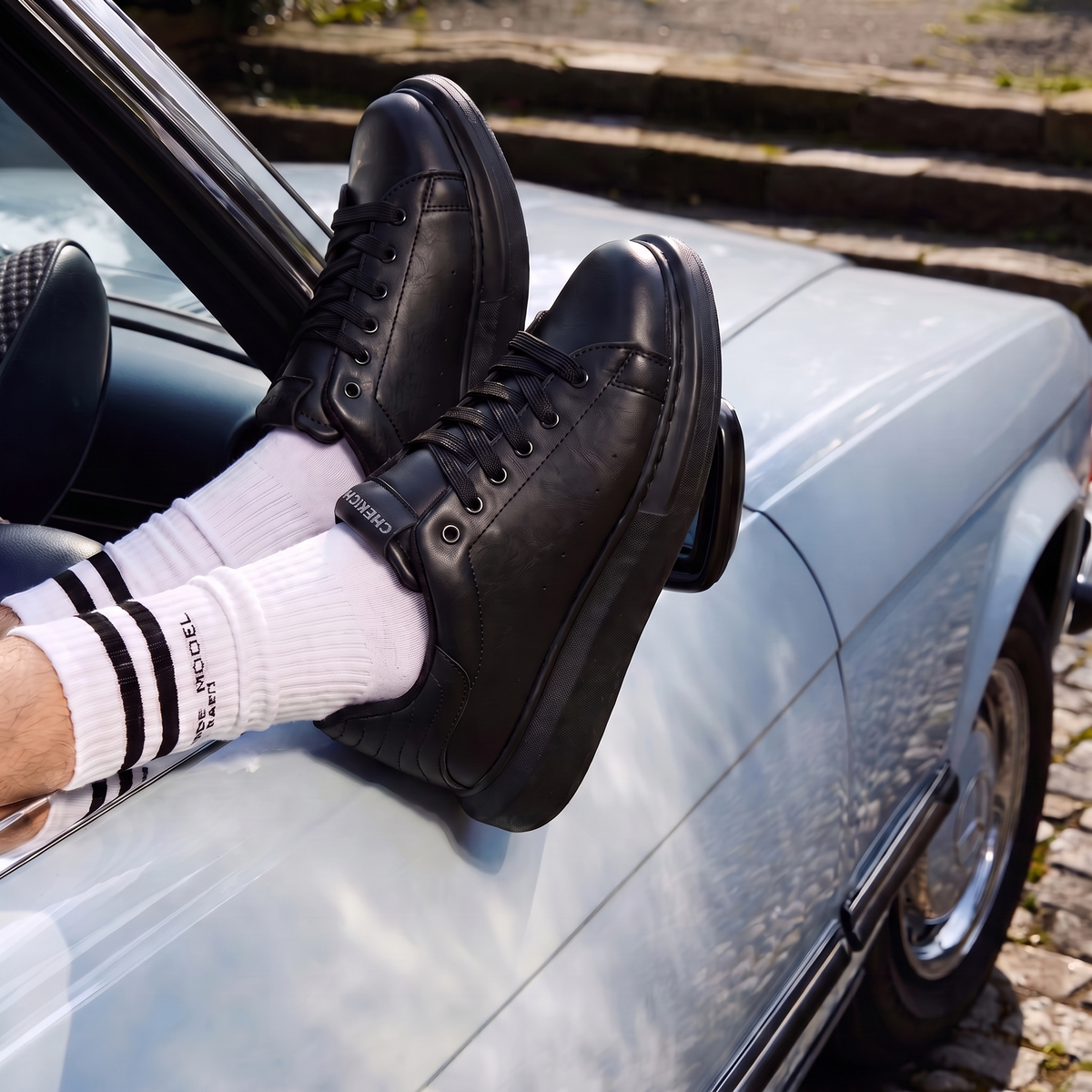 Black ORIGIN Sneakers by Shopify, featuring sleek all-black design with laces and minimalist style, displayed on a white background.