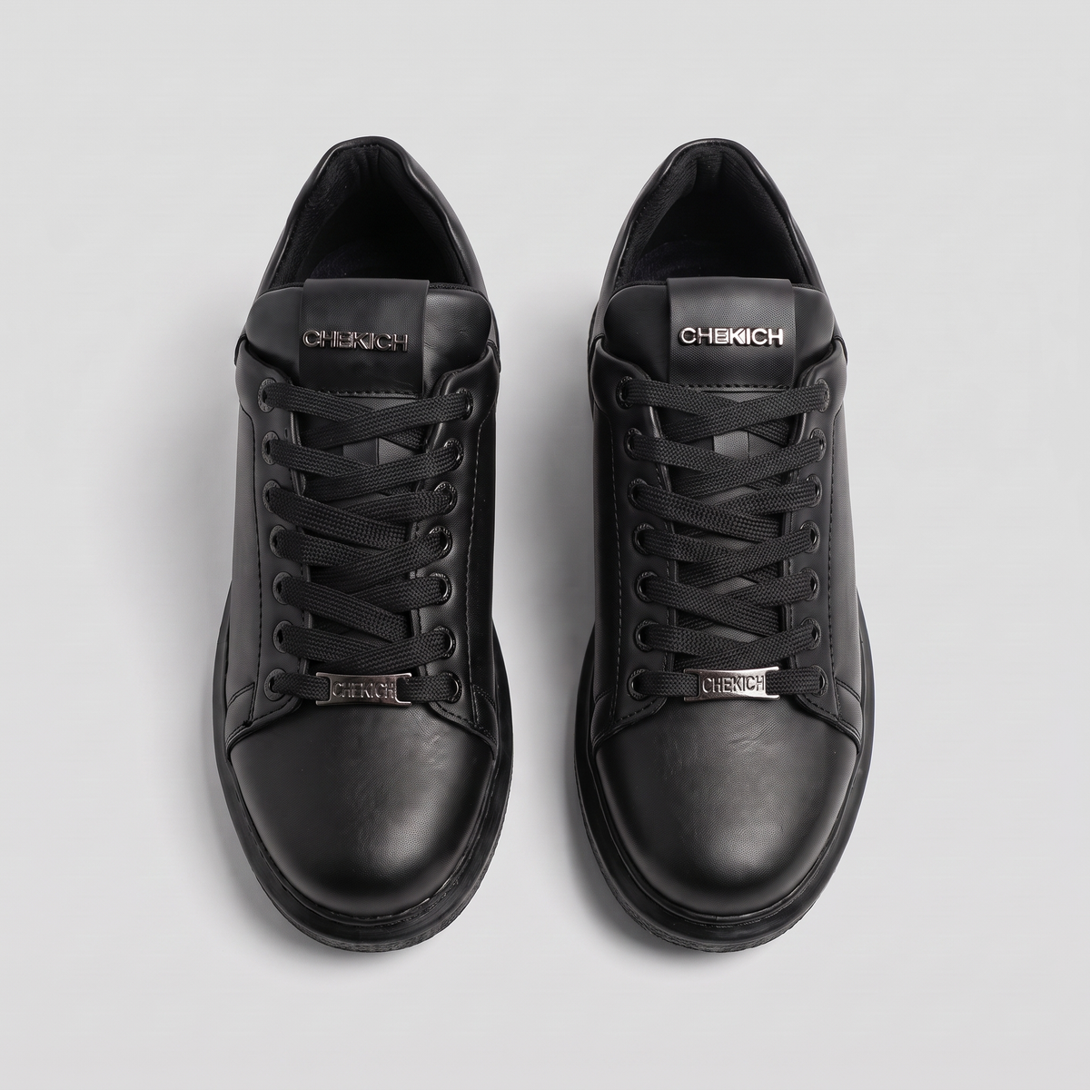 Black Fantasia Plain sneakers by Shopify featuring a sleek, minimalist design with smooth black material and white sole detail.
