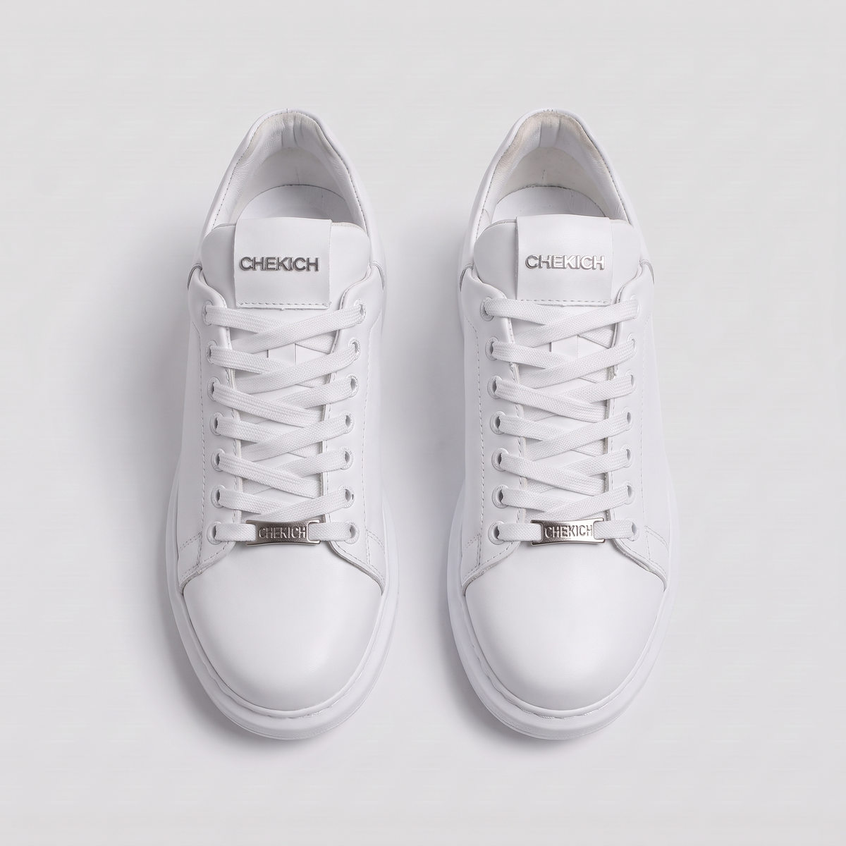 White FANTASIA Plain sneakers by Shopify with clean design and white laces, displayed on a neutral background.