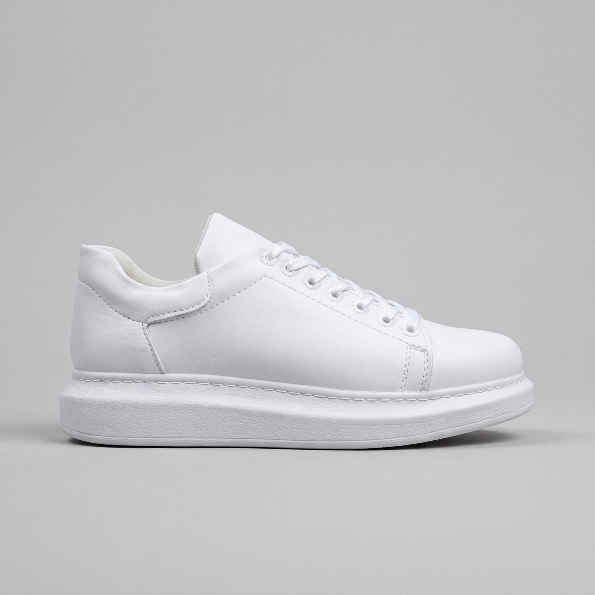 White Shopify Fantasia Plain sneakers shown from side view, featuring clean design and white laces on a white background.